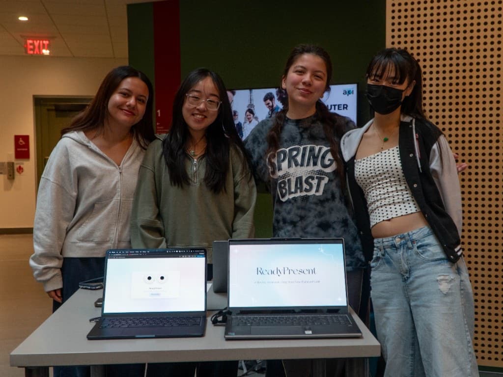 Four students presenting ReadyPresent on two laptop screens at demo time.